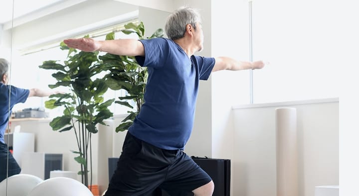 室内でストレッチをする中高年の男性